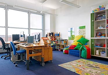 Foto eines Eltern-Kind-Zimmers beim BKA: ein Büro mit Schreibtisch und Spielecke.