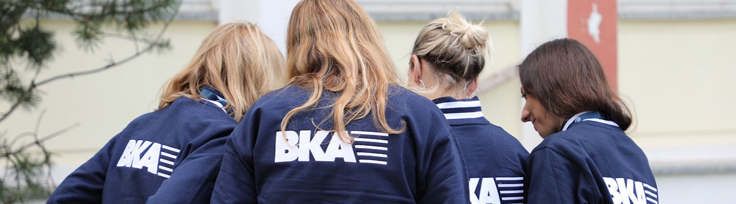 Vier Damen mit Rückansicht tragen Jacken mit dem Schriftzug des BKAs 